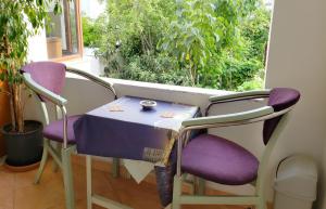 uma pequena mesa e duas cadeiras num quarto com uma janela em My Home Guest House em Durrës