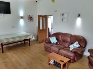 a living room with a couch and a coffee table at Brook Barn B&B in Hale