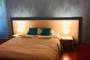 a bedroom with a large bed with two lamps at Atrium Panzio in Esztergom