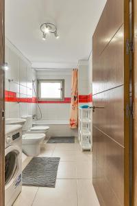 uma casa de banho com um lavatório e uma máquina de lavar roupa em Apartamento nuevo en Alcalá, con aparcamento, con aircondicionador em Alcalá