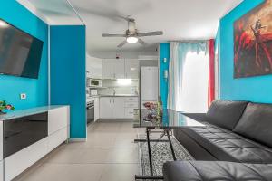 a living room with a couch and a blue wall at Apartamento en Alcalá, con aparcamento, con aircondicionador in Alcalá