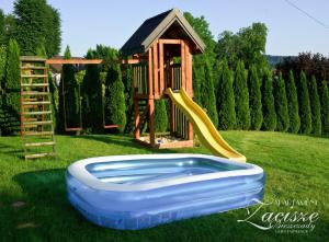 a playground with a slide and a play house at Apartament Zacisze in Uherce Mineralne