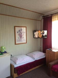 um quarto com duas camas e uma televisão na parede em Pokoje Gościnne em Mielno