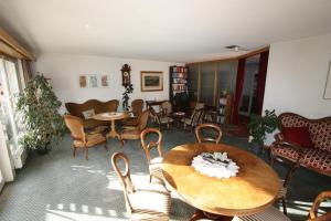 a living room with a table and chairs at Hotel Restaurant Alpina in Grindelwald
