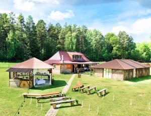 a group of picnic tables and tents in a field at Guest House Gravas in Bauska