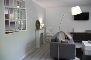 a living room with a couch and a floor lamp at Große, helle Ferienwohnung mit 2 Balkonen auf dem Bauernhof in der Lüneburger Heide in Oetzen