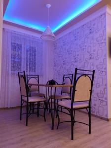 una sala da pranzo con tavolo e sedie con luce blu di Apartment a Sevan