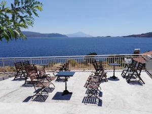 a group of chairs and tables with a view of the water at Villa Elli in Ammouliani