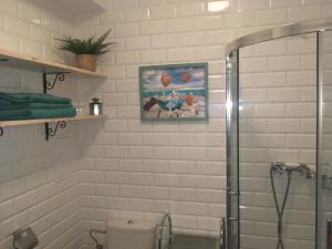 biała łazienka z prysznicem i toaletą w obiekcie Apartament Wrzos w Dziwnówku +37 zdjęć