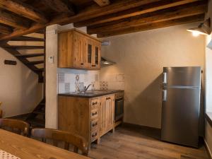 een keuken met een roestvrijstalen koelkast en houten kasten bij Appartements Moraine Enchantée - CIR 82 CIR 83 in Aosta