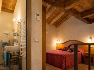 een slaapkamer met een bed en een wastafel in een kamer bij Appartements Moraine Enchantée - CIR 82 CIR 83 in Aosta