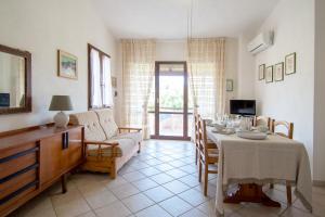 a living room with a table and a couch at Rosa Holiday Home in Villasimius