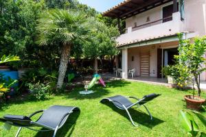 ヴィッラシミーウスにあるRosa Holiday Homeの芝生の椅子2脚と遊び場のある庭