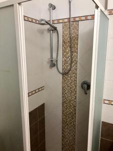 a shower with a glass door in a bathroom at Sa Corti Antiga Apartment in SantʼAntìoco +8 photos