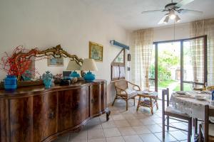 a living room with a large wooden cabinet and a table at Rosa Holiday Home in Villasimius