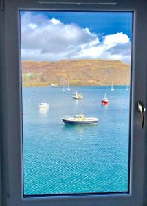 a view of boats in the water from a window at Quayside Apartment in Portree