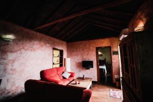 uma sala de estar com um sofá vermelho e uma mesa em Casa Elena em Tijarafe