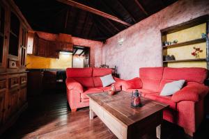 uma sala de estar com duas cadeiras vermelhas e uma mesa em Casa Elena em Tijarafe