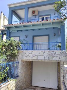 een blauw huis met een garage bij Maisonette Ilios in Plisioí