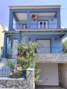 ein blaues Haus mit einem Balkon in der Unterkunft Maisonette Ilios in Plisioí