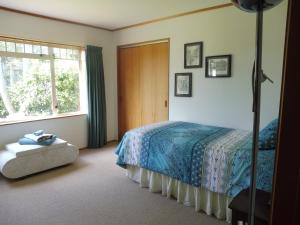 a bedroom with a bed and a window at Hideaway Off Heta in New Plymouth