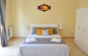 una camera da letto con un grande letto con cuscini arancioni di B&B Etna Shanti a Santa Venerina