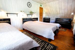 a bedroom with two beds and a clock on the wall at Mi Sann Holiday Home in Haanja