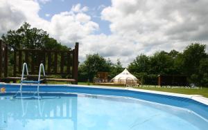 a large swimming pool with a gazebo in the background at Mobile Home at La Petite Lande in Pierrefiche