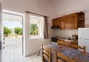 a small kitchen with a table and a refrigerator at Ambelakia Studios in Monemvasia