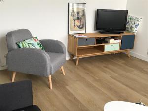 a living room with a tv and a chair at Appartement Saint-Nicolas in La Rochelle