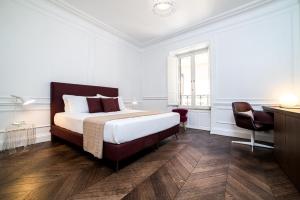 a bedroom with a bed and a desk and a chair at Youroom Carrozze in Rome