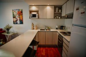 a kitchen with a white counter top and a refrigerator at Ribera de Pipo Cálido departamento para tu estancia in Ushuaia