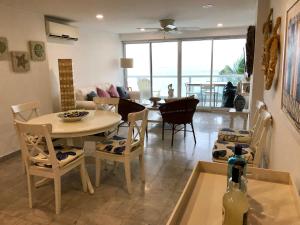 a dining room and living room with a table and chairs at Apartamento Sunrise con vista interna o con vista al mar in San Andrés