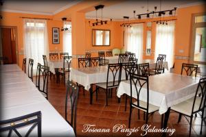 a dining room with white tables and chairs at Toscana Panzió in Zalacsány