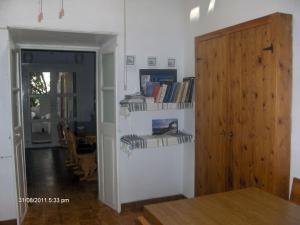 a room with shelves with books and a wooden door at The little bougainvillea house in Kythira