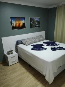 1 dormitorio con 1 cama grande con colcha blanca en Yacht Village Natal Top, en Natal