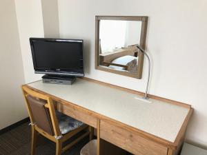 a room with a desk with a television and a mirror at Ichinomiya Green Hotel in Ichinomiya