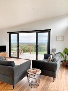 a living room with two couches and a large window at By Moonlight in Wattle Hill