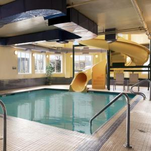een zwembad met een glijbaan in een gebouw bij Super 8 by Wyndham Slave Lake AB in Slave Lake