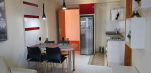 eine Küche mit einem Tisch und Stühlen sowie einem Kühlschrank in der Unterkunft Apartamento Giardino Rio Quente in Rio Quente