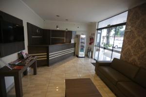 a living room with a couch and a refrigerator at Hotel Vivere Cataratas in Foz do Iguaçu