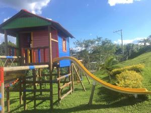 a playground with a slide in front of a house at Reserva de la Colina in La Tebaida