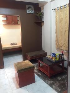 een woonkamer met een tafel en een bed bij Las Pinas Serviced Apartment in Manilla