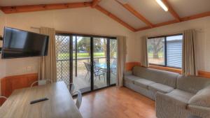 a living room with a couch and a table at Myrtleford Holiday Park in Myrtleford