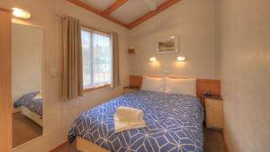 a bedroom with a bed and a window at Yea Riverside Caravan Park in Yea