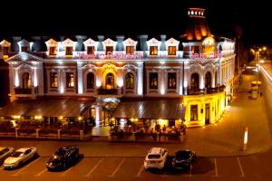un edificio con auto parcheggiate davanti di notte di Hotel Select a Iaşi