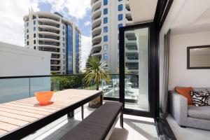 a balcony with a table and a chair on a balcony at Ocean Eleven 5 in Mount Maunganui