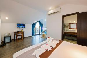 Postel nebo postele na pokoji v ubytování December Hoi An Villa