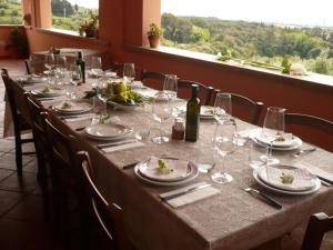 a long table with glasses and plates and wine bottles at Agriturismo De Santis in Castiglioncello