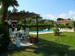 a backyard with a table and chairs and a pool at Agriturismo De Santis in Castiglioncello
